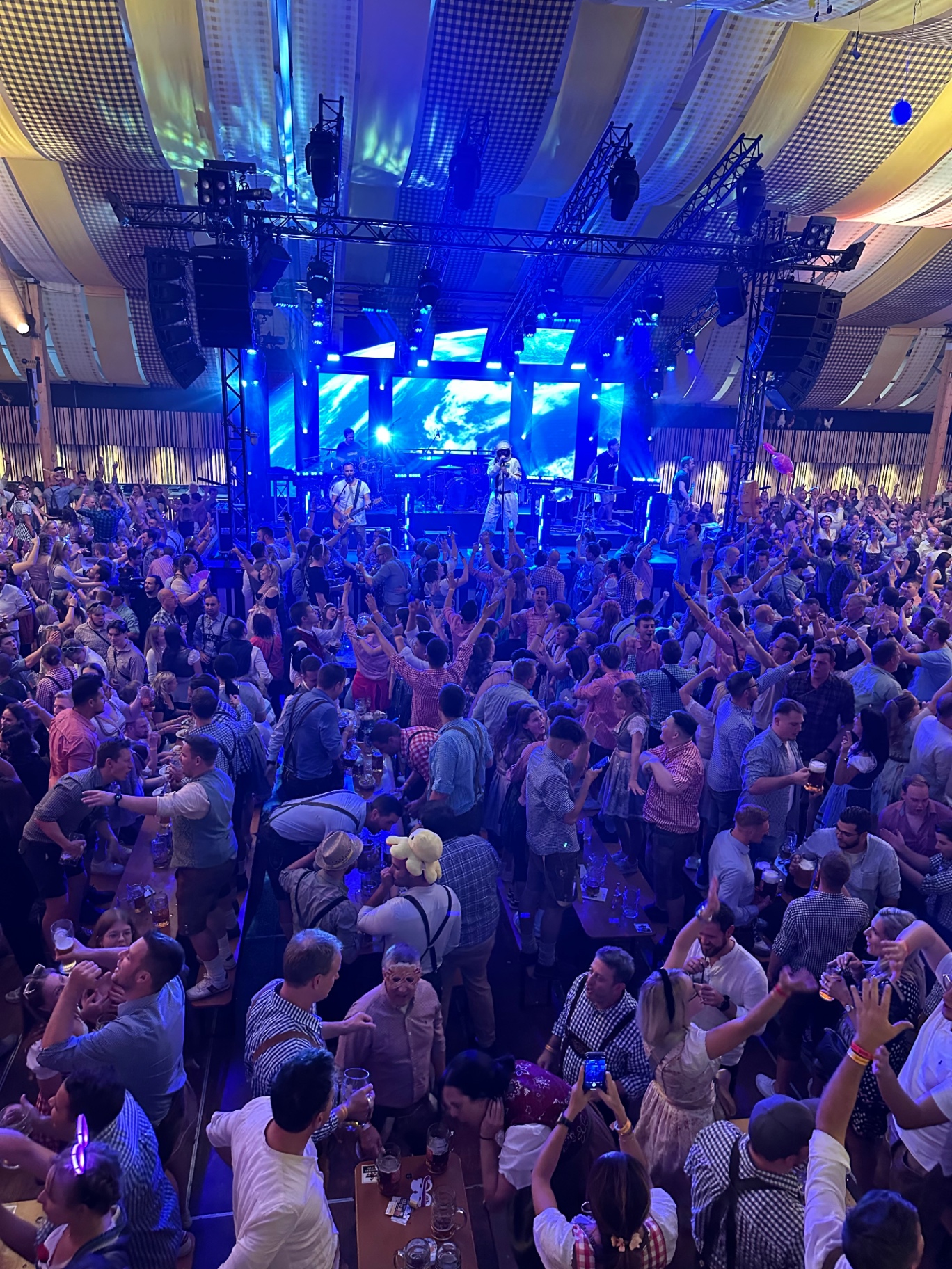 Festzelt in blauem Licht mit jubelndem Publikum